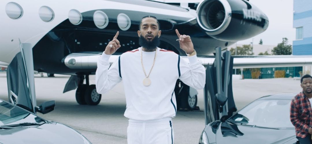Nipsey Hussle in front of a plane